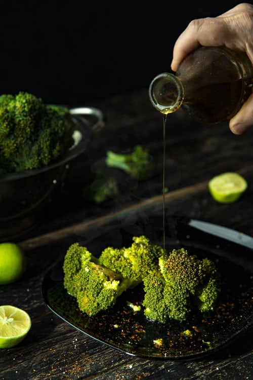 Oil being poured onto broccoli a plant based protein