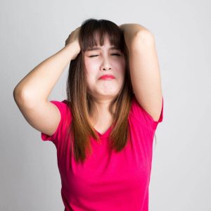 woman frustrated in red shirt pulling at hair