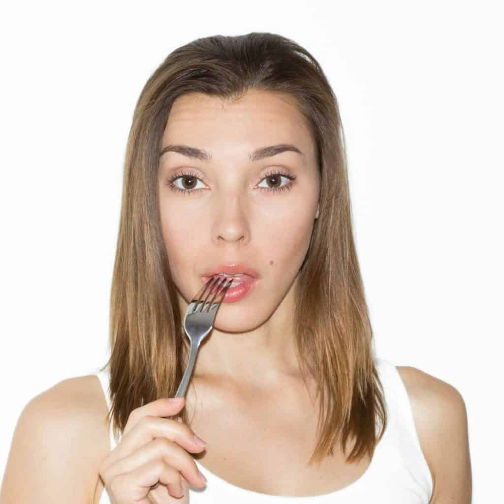 woman putting fork to her lips