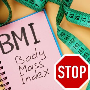 Notebook with the words BMI, a stop sign and a green tape measure