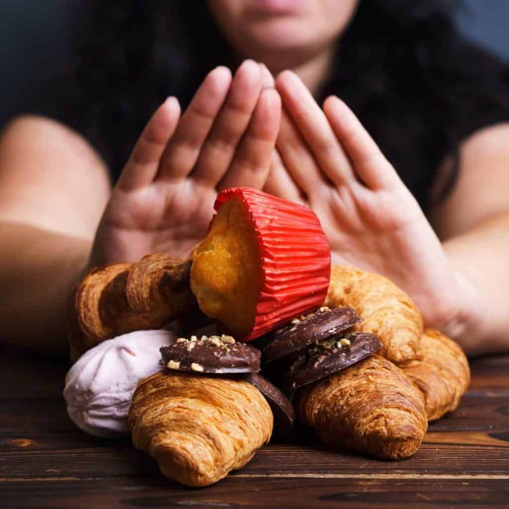 person pushing away pastries with two hands