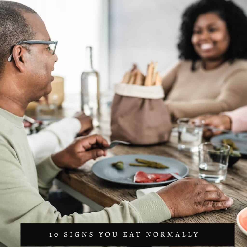 woman smiling at a table with man with bread on table