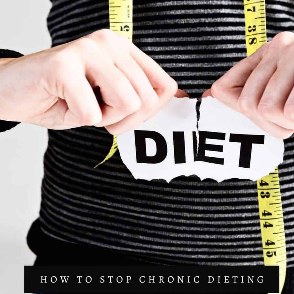 person tearing the word diet on paper