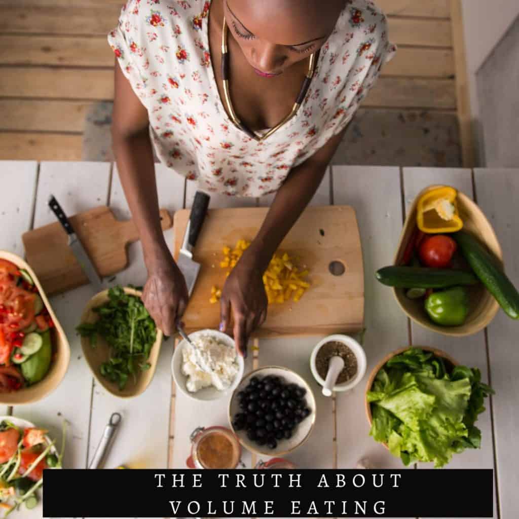 woman sitting at a table with lots of fruits and vegetables